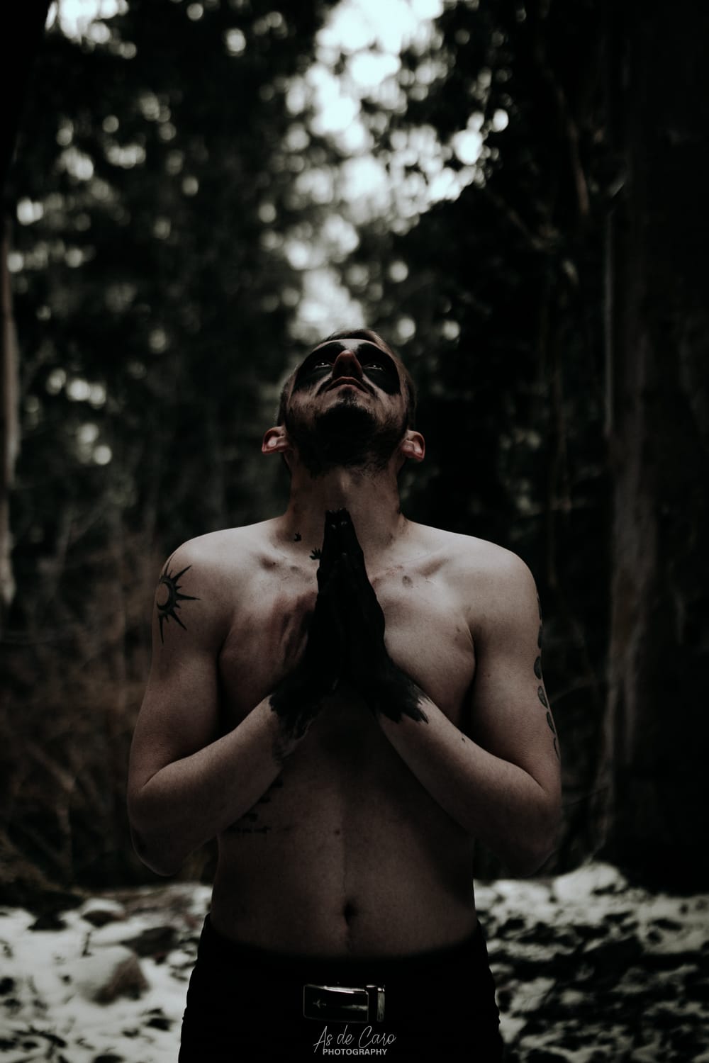 Portrait artistique dark d'un homme torse nu avec des tatouages et les mains noires à Chambéry